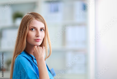 Doctor woman is standing in the near window photo