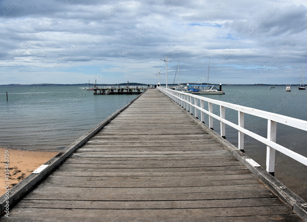 Old wood bridge pier at Rhyll (Philip Island, Victoria, Australia). Old wooden jetty with natural background.