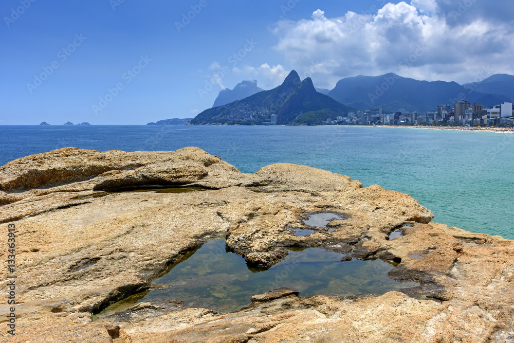 Rio de Janeiro, Ipanema beach, Gavea stone and Two Brothers hill seen through the Arpoador stones