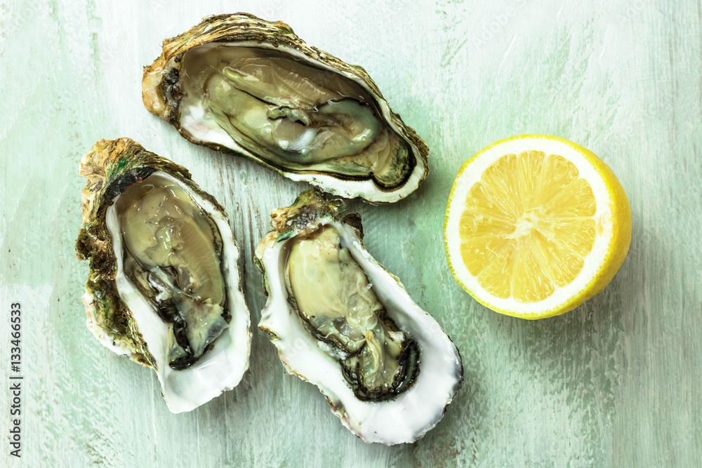 Freshly opened oysters with slice of lemon Freshly opened oysters with slice of lemon