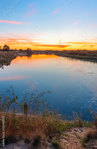 River at sunset sky background