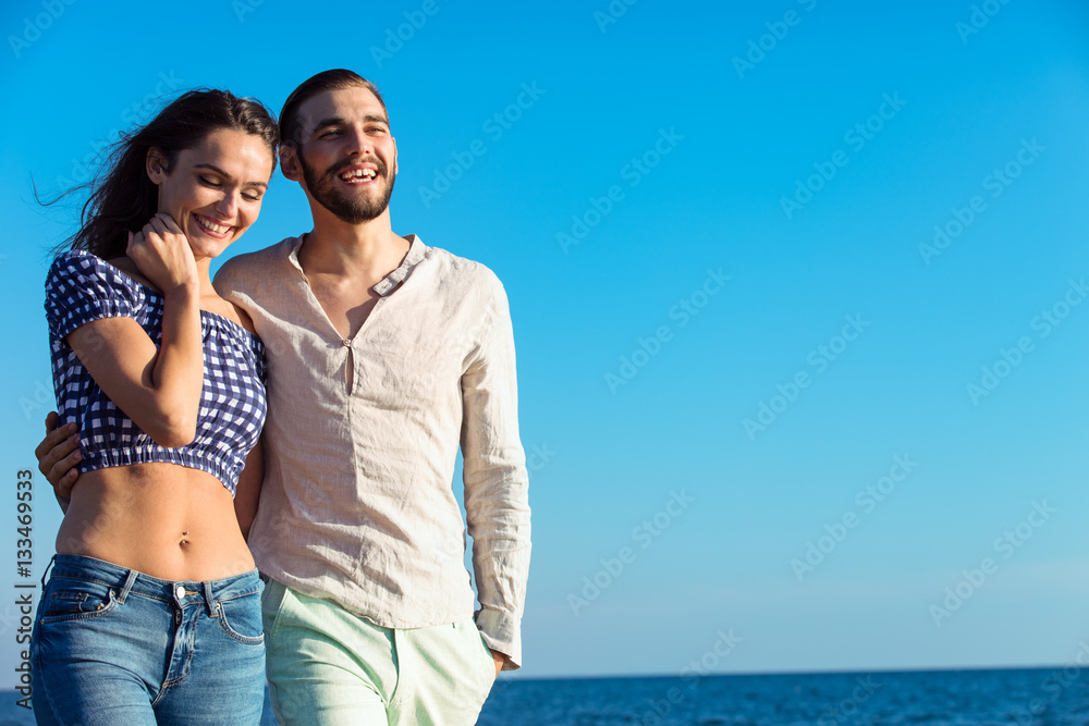 Couple walking on beach. Young happy interracial couple walking on beach. Couple walking on beach. Young happy interracial couple walking on beach.