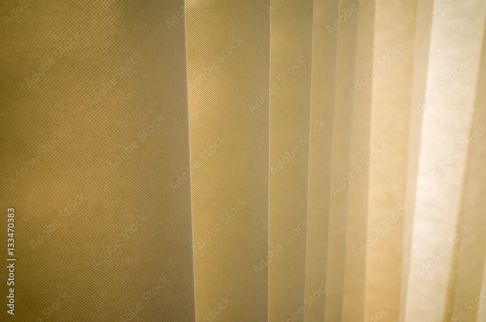 Obraz premium Hanging dividing curtain in a hospital ward. Folding room divider. Privacy curtain with multiple folds. Medical curtain hanging from a railing in a hospital room.