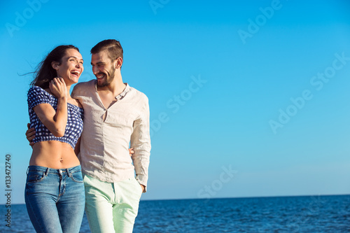 Couple walking on beach. Young happy interracial couple walking on beach.
