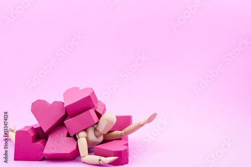 Wooden dummy was crushed by a pile of paper box red heart shape