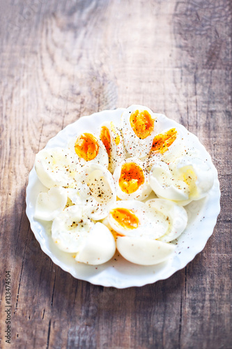 Hard boiled eggs, sliced in halves with black pepper spice on wh