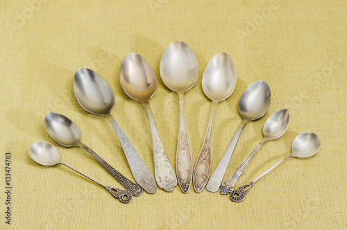 Several different old spoons on cloth