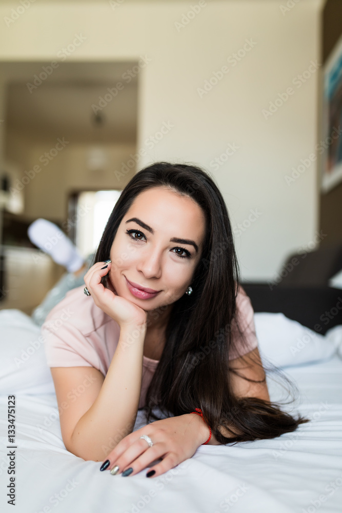 Brunette girl relax in her bed at home Brunette girl relax in her bed at home