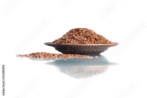 Wooden bowl with linen seeds isolated on white background. Close