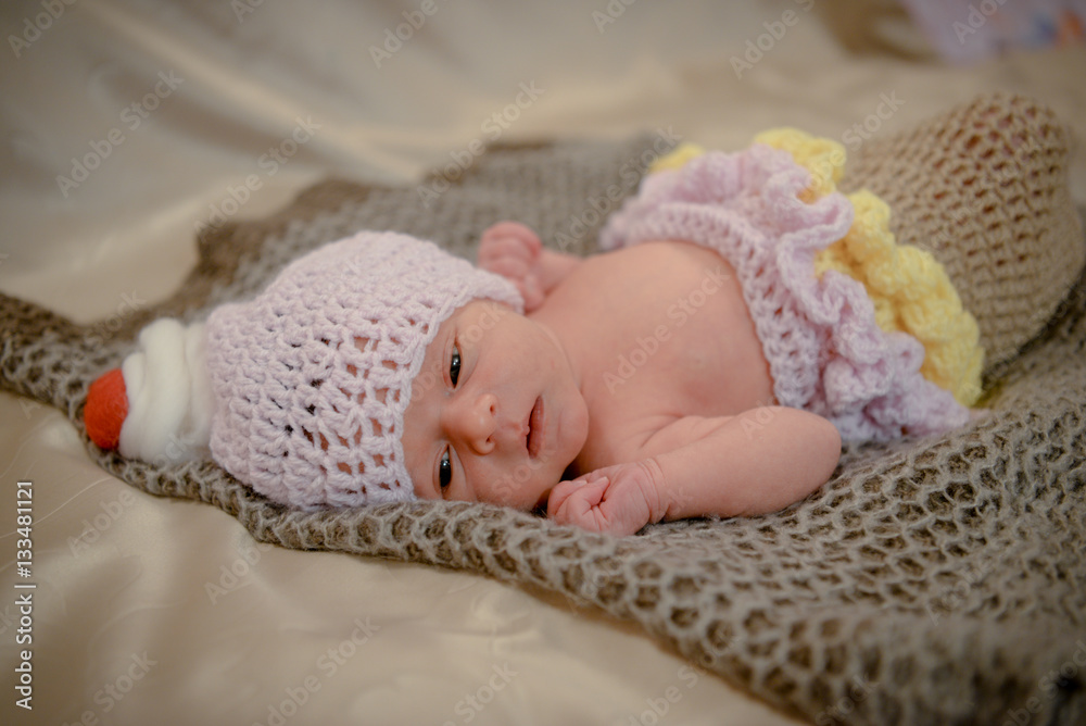 Portrait of a newborn baby infant toddler in bed. Close up top view