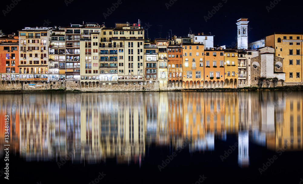 Florence at night is reflected in the Arno river