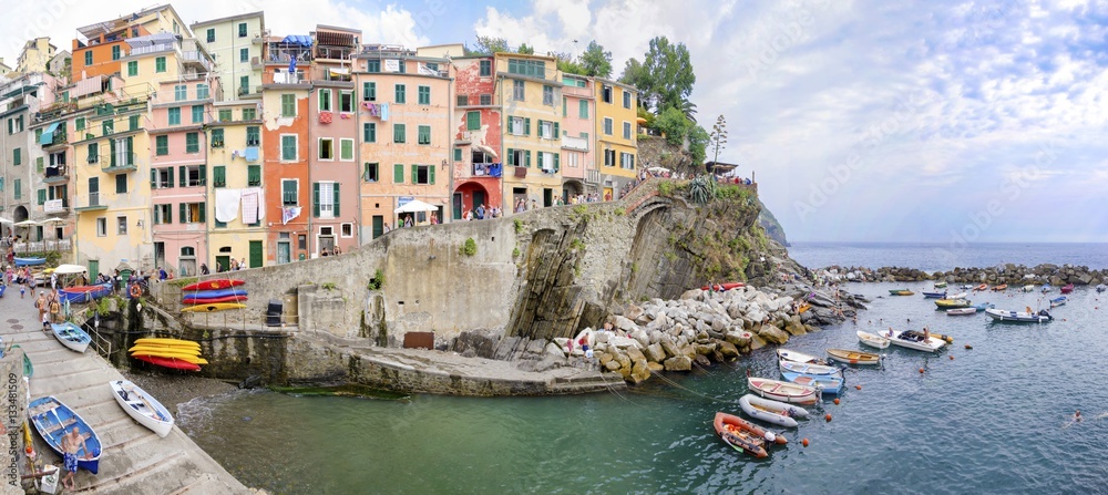 Riomaggiore village,La Spezia,Liguria,northern Italy.Colorful houses on steep hills,sea rocks,beach,laundry on balconies,boats. Part of the Cinque Terre National Park and a UNESCO World Heritage Site.
