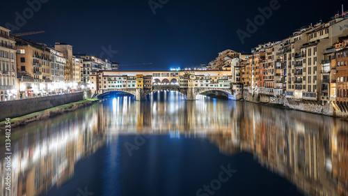 Ponte Vecchio at night is reflected in the Arno river in Florence, Italy   © Gian78