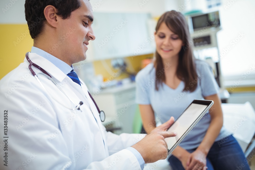 Doctor using digital tablet while consulting patient Doctor using digital tablet while consulting patient