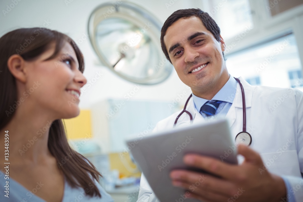 Portrait of doctor using digital tablet while consulting patient Portrait of doctor using digital tablet while consulting patient