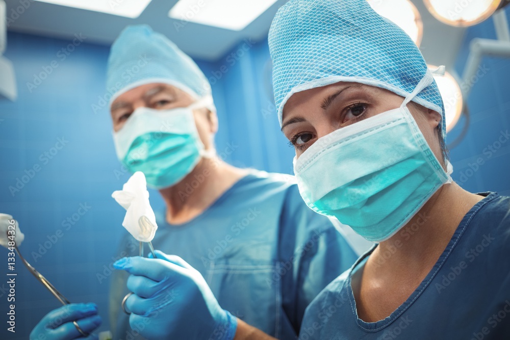 Portrait of surgeons wearing surgical mask in operation theater