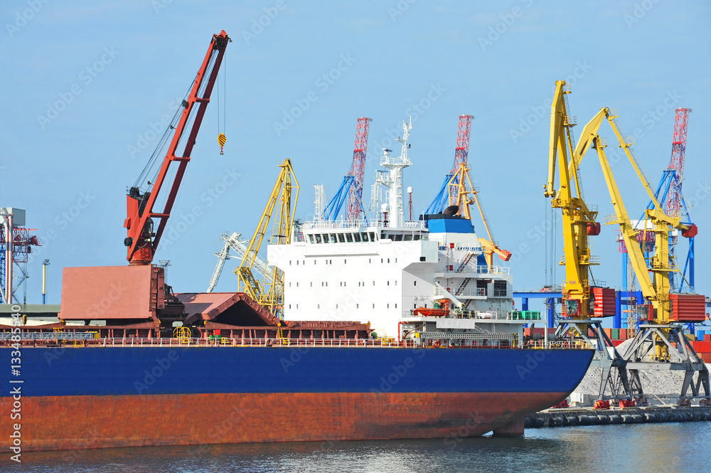 Obraz premium Bulk cargo ship under port crane