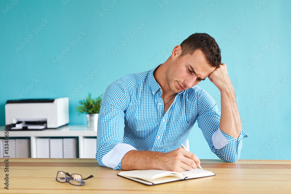 Businessman sitting in his office and writing plan Businessman sitting in his office and writing plan