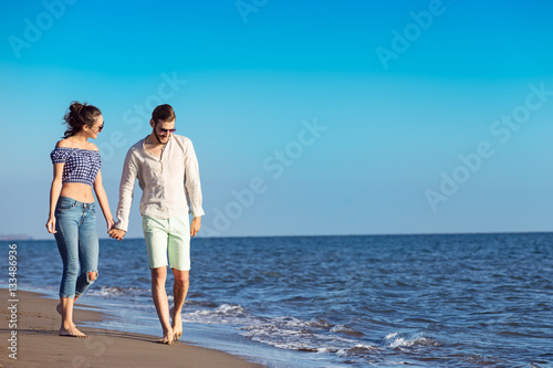 Couple walking on beach. Young happy interracial couple walking on beach.