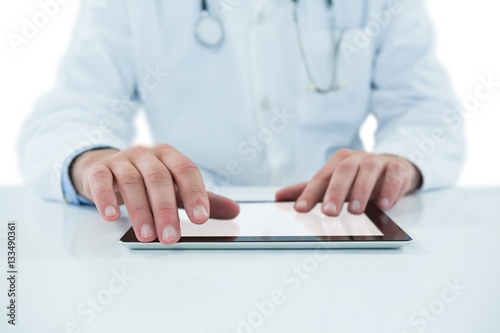 Doctor examining with stethscope against white background