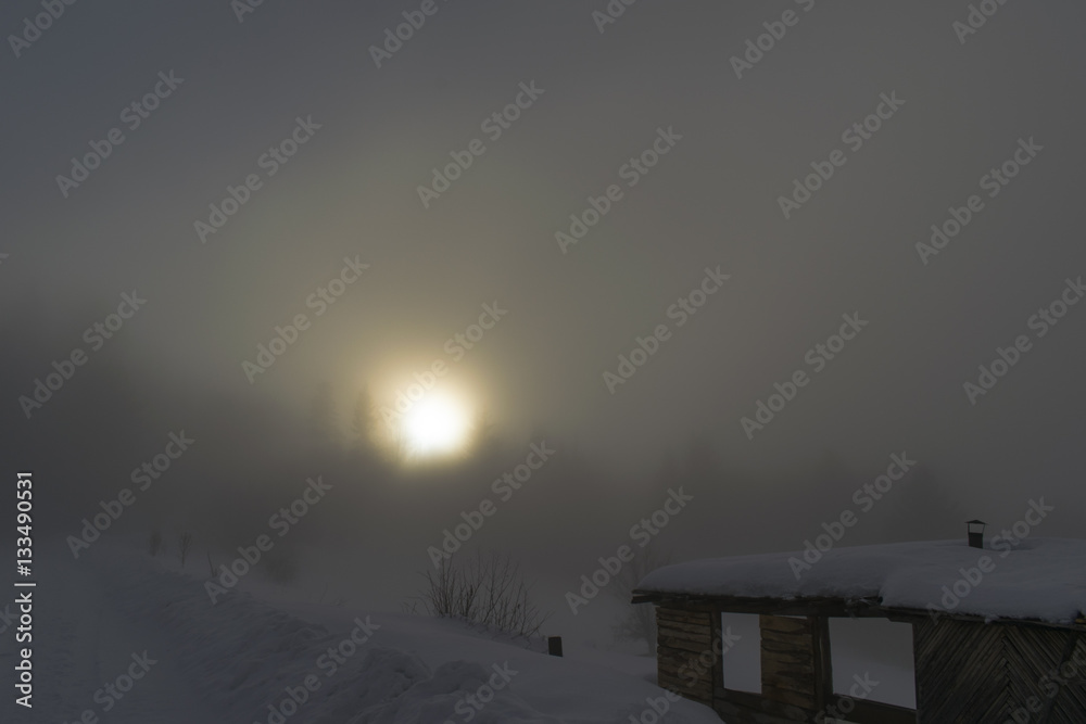 Foggy sun behind clouds and the misty house Foggy sun behind clouds and the misty house