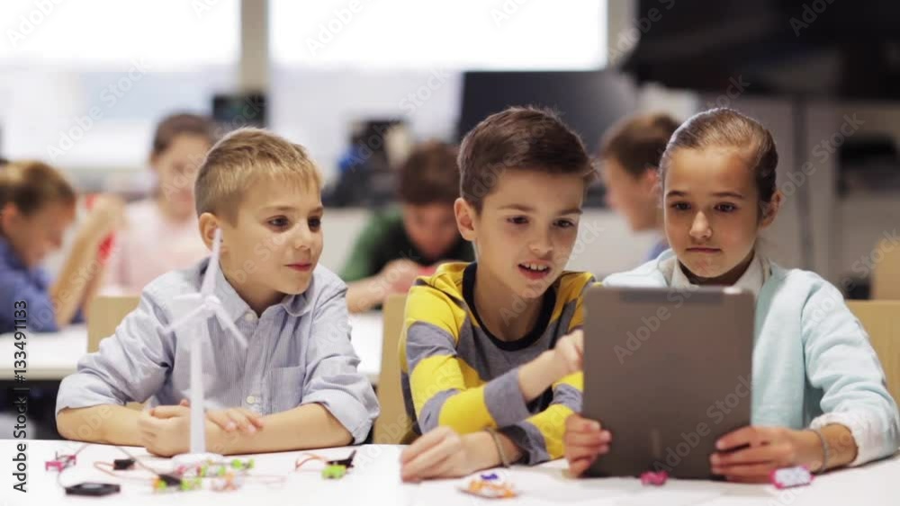 kids with tablet pc programming at robotics school