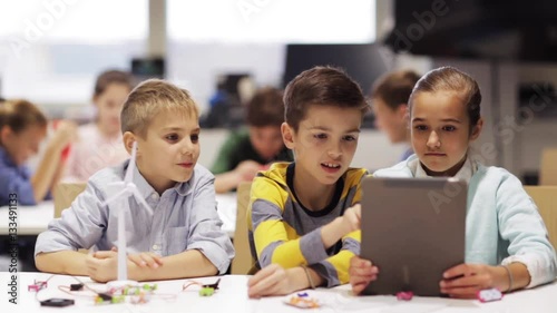 kids with tablet pc programming at robotics school