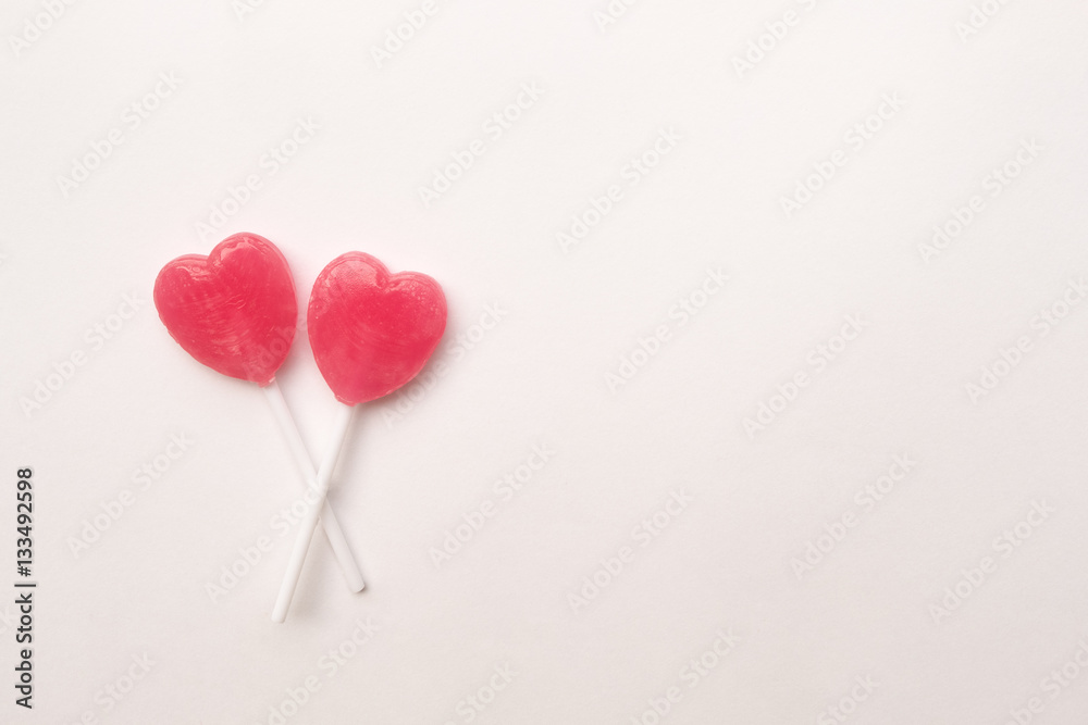 two Pink Valentine's day heart shape lollipop candy on empty white paper background. Love Concept. Knolling top view. Minimalism colorful hipster style.