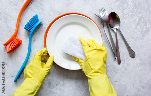 concept of woman washing dishes on gray background top view photo