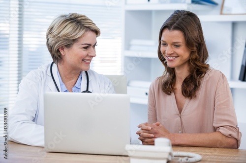 Doctor discussing with patient over laptop