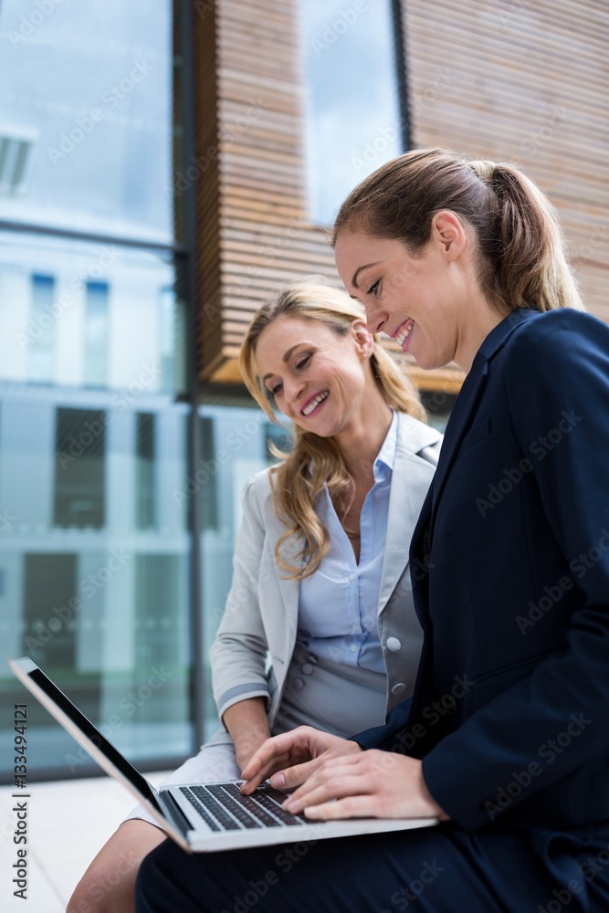 Businesswomen sitting and using laptop Businesswomen sitting and using laptop