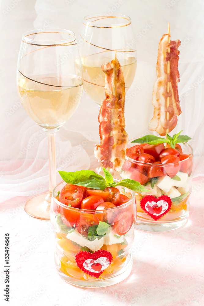 Festive caprese salad with fried bacon on skewers in glasses Festive caprese salad with fried bacon on skewers in glasses