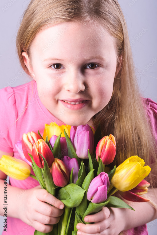 Smiling blond girl with a bouquet of tulips. Smiling blond girl with a bouquet of tulips.