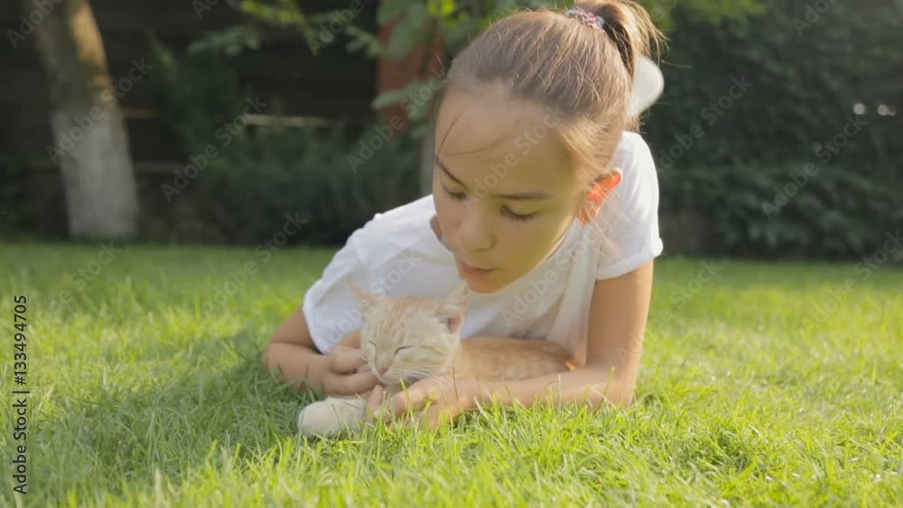 Portrait of cute teenage girl with red kitten on grass at garden Portrait of cute teenage girl with red kitten on grass at garden
