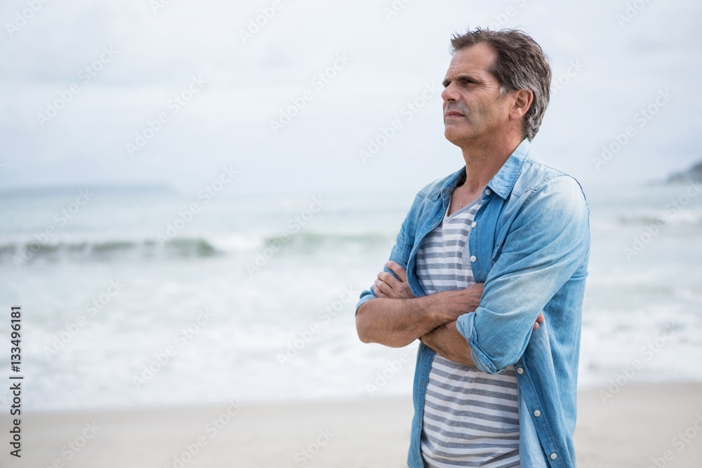Thoughtful man standing on beach Thoughtful man standing on beach