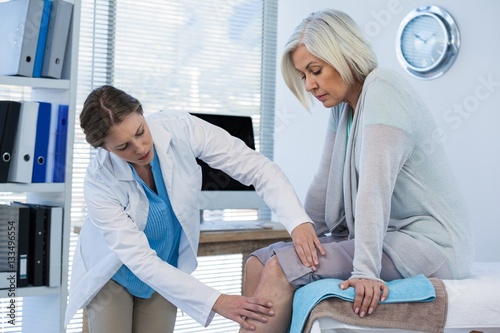 Fotografi Doctor examining patient knee