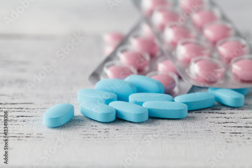 Various pills and capsules in blister packagings piled up on a t