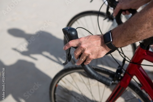 Close-up of mans hand wearing smartwatch while riding bicycle