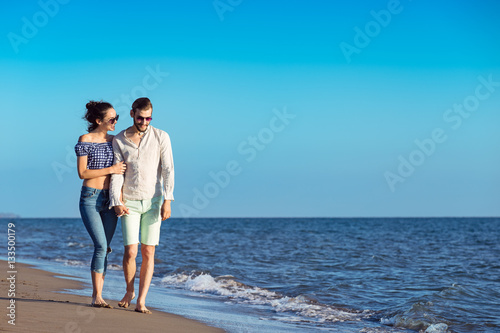 Couple walking on beach. Young happy interracial couple walking on beach. © FS-Stock