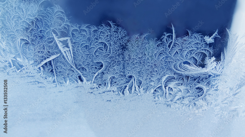 Ice flowers frozen window background. macro view photography frost textured pattern. cold winter weather xmas concept.