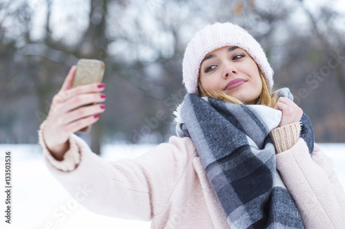 Beautiful blonde woman taking a selfie in winter holidays on the © nikodash