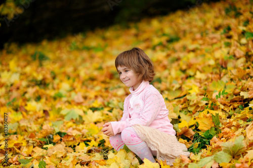 happy little child, laughing and playing in the autumn