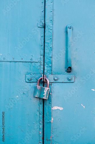 Hanging metal lock on emerald paint color metallic door. Closed private object vintage style © besjunior