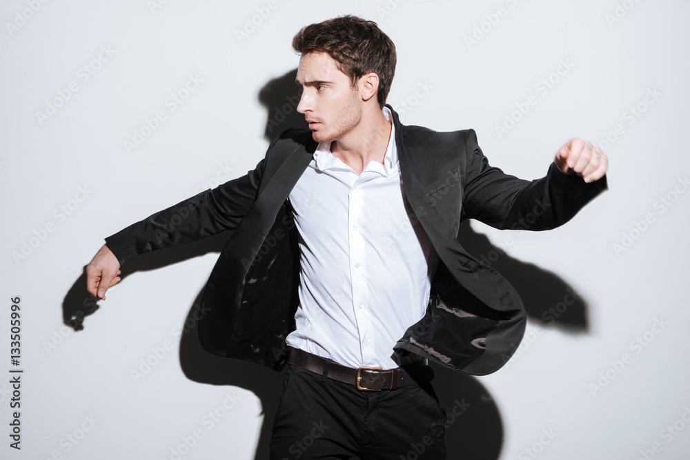 Serious handsome businessman standing at studio Serious handsome businessman standing at studio