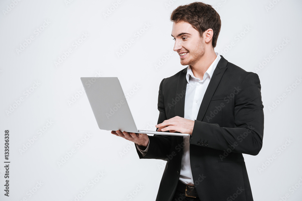 Handsome young caucasian businessman holding laptop