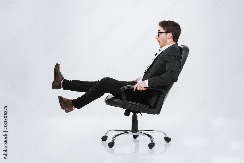 Handsome businessman sitting on chair at studio. Handsome businessman sitting on chair at studio.