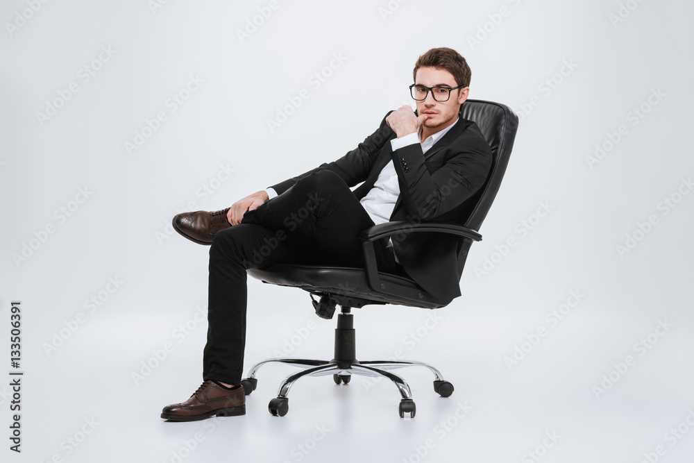 Businessman sitting on chair at studio. Businessman sitting on chair at studio.