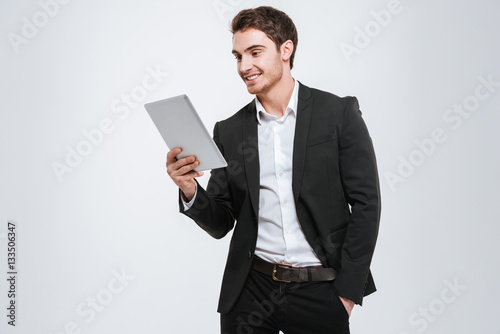 Young caucasian businessman holding tablet computer