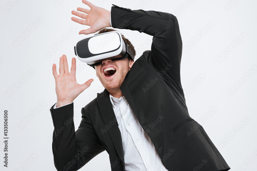 Young businessman standing at studio wearing 3d glasses virtual reality. Young businessman standing at studio wearing 3d glasses virtual reality.