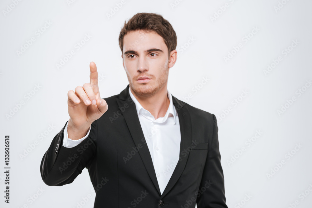 Attractive businessman standing at studio and pointing. Attractive businessman standing at studio and pointing.